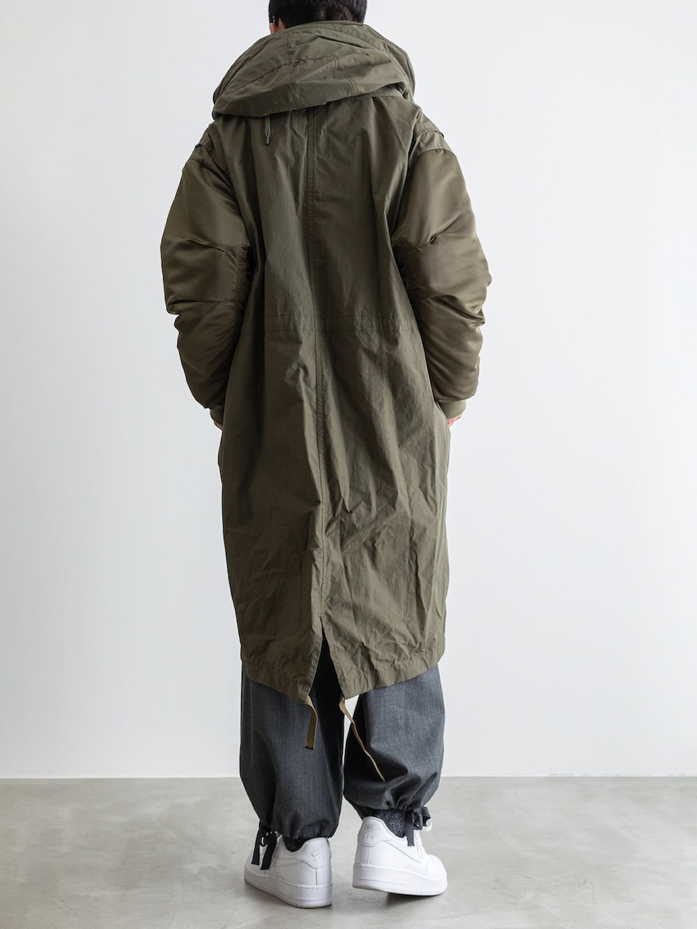 グリーン系のモッズコート、グレー系のその他パンツ、グレー系のTシャツ/カットソーを着用したメンズの冬コーディネートの3枚目の写真