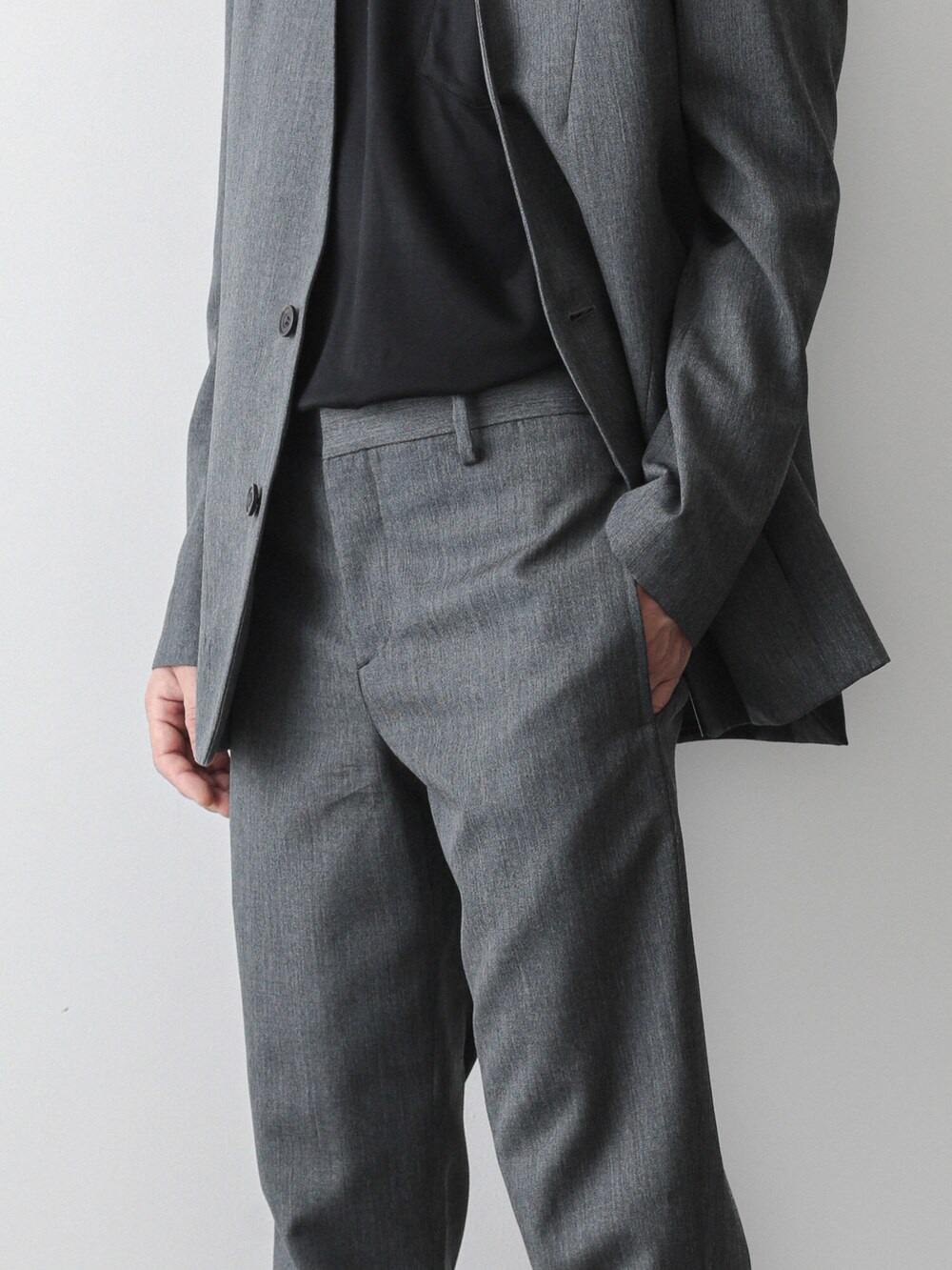 グレー系のノーカラージャケット、グレー系のスラックス、ブラック系のTシャツ/カットソーを着用したメンズの夏コーディネートの3枚目の写真