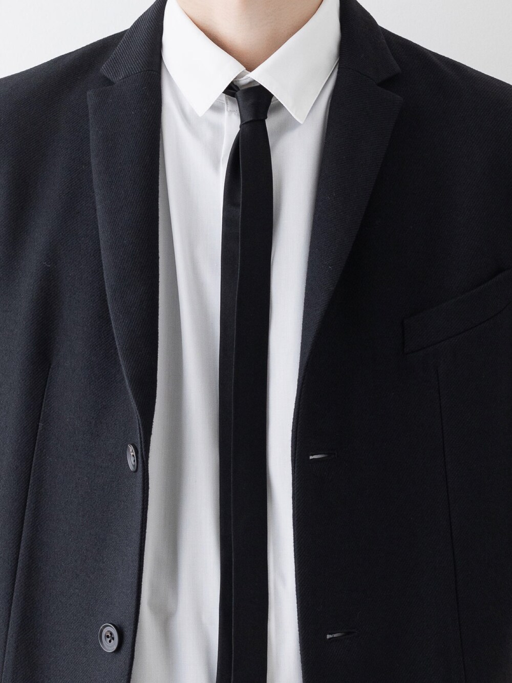 ブラック系のチェスターコート、ホワイト系のシャツ/ブラウス、ブラック系のその他パンツを着用したメンズの秋コーディネートの4枚目の写真