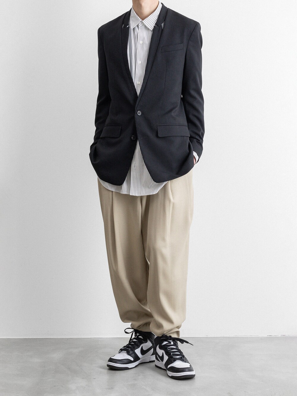 ブラック系のテーラードジャケット、ベージュ系のその他パンツを着用したメンズの冬コーディネートの5枚目の写真