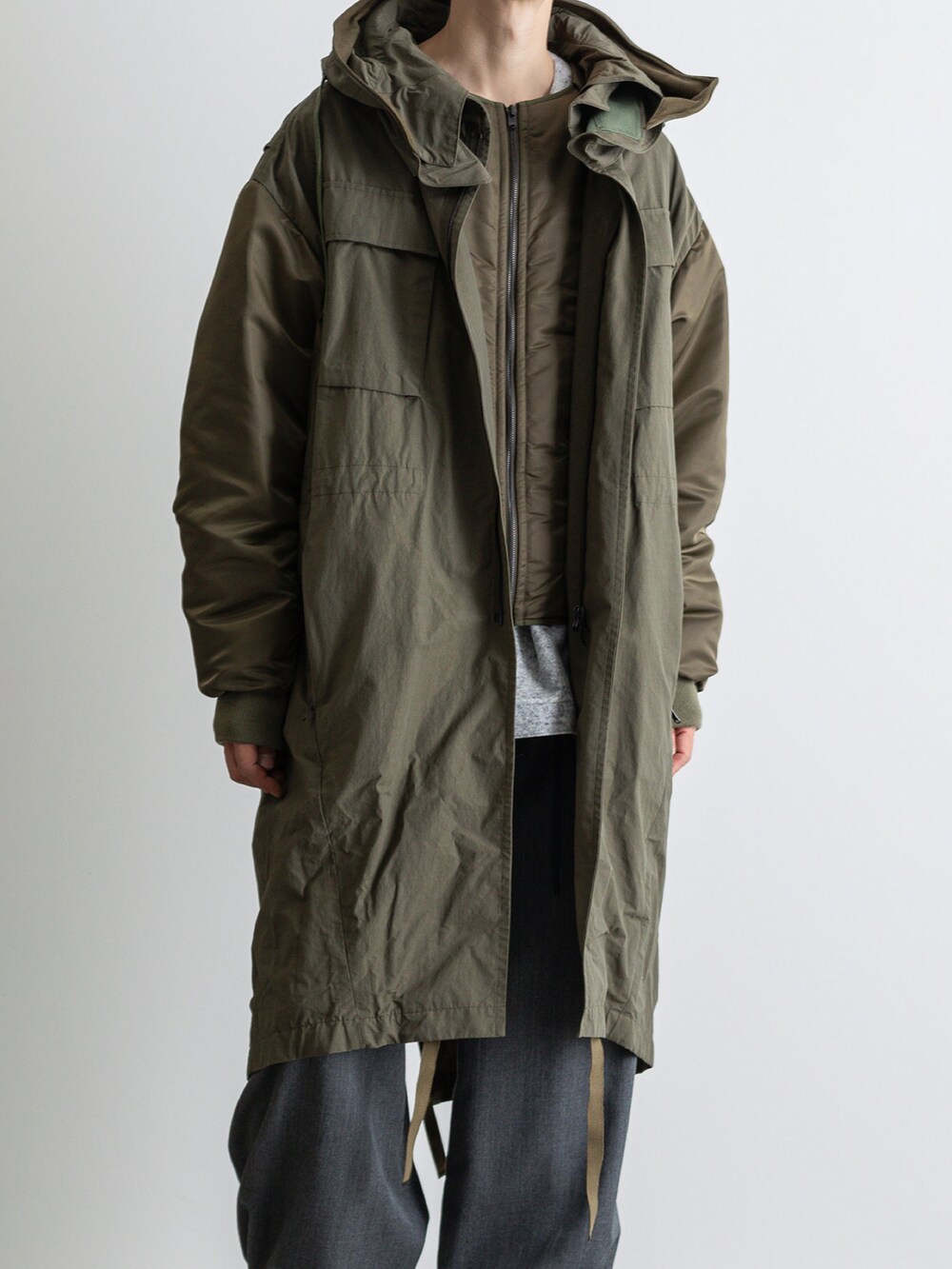 グリーン系のモッズコート、グレー系のその他パンツ、グレー系のTシャツ/カットソーを着用したメンズの冬コーディネートの4枚目の写真