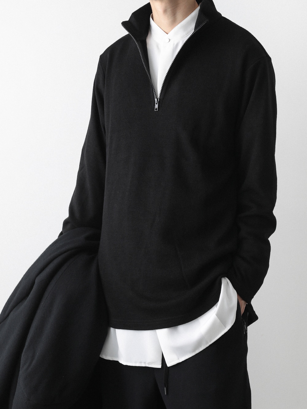 ブラック系のトレンチコート、ホワイト系のシャツ/ブラウス、ブラック系のTシャツ/カットソーを着用したメンズの秋コーディネートの4枚目の写真