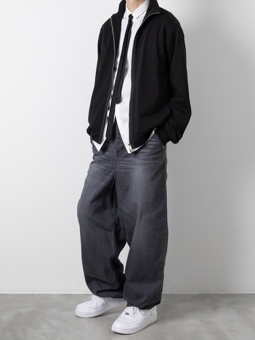 ブラック系のデニムパンツ、ブラック系のネクタイ、ブラック系のニット/セーターを着用したメンズの秋コーディネートの3枚目の写真