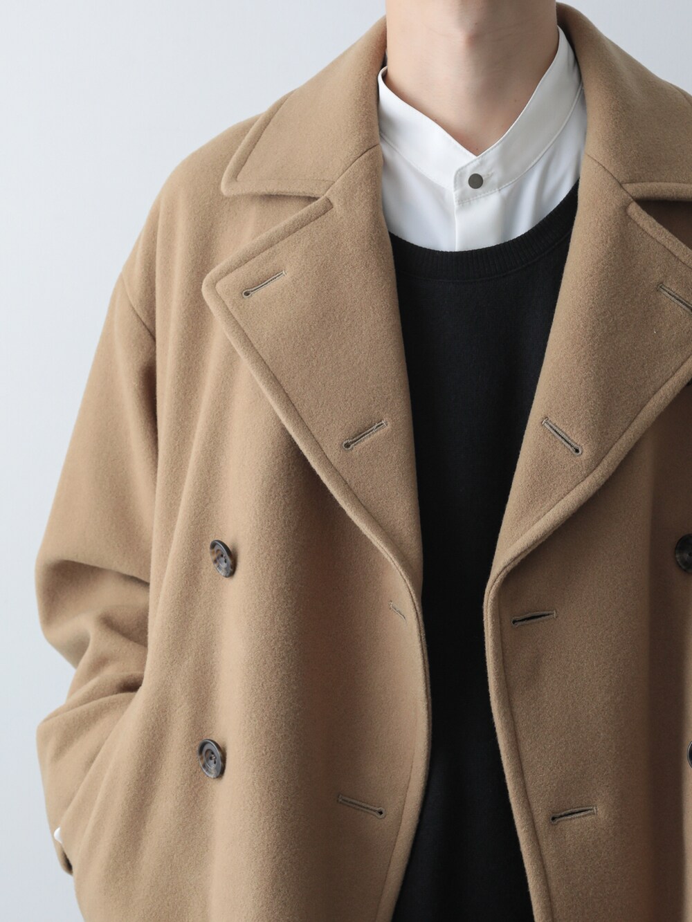 ベージュ系のピーコート、ホワイト系のシャツ/ブラウス、ブラック系のTシャツ/カットソーを着用したメンズの秋コーディネートの2枚目の写真