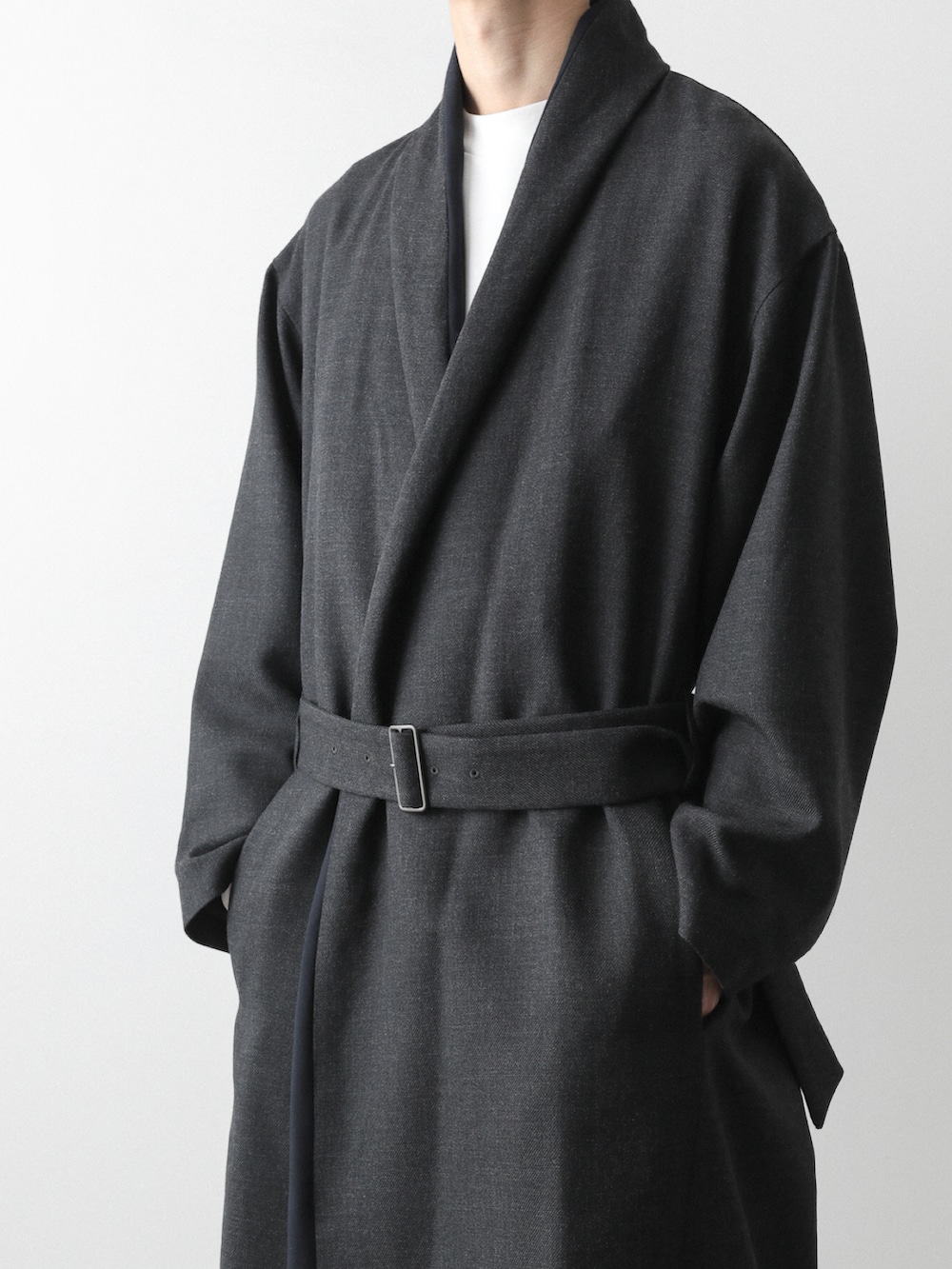 グレー系のノーカラーコート、ブラック系のその他パンツを着用したメンズの秋コーディネートの2枚目の写真