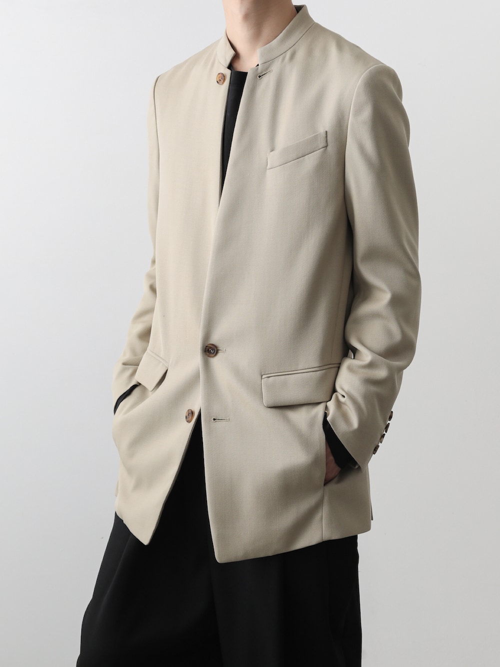 ベージュ系のテーラードジャケット、ブラック系のその他パンツを着用したメンズの秋コーディネートの3枚目の写真