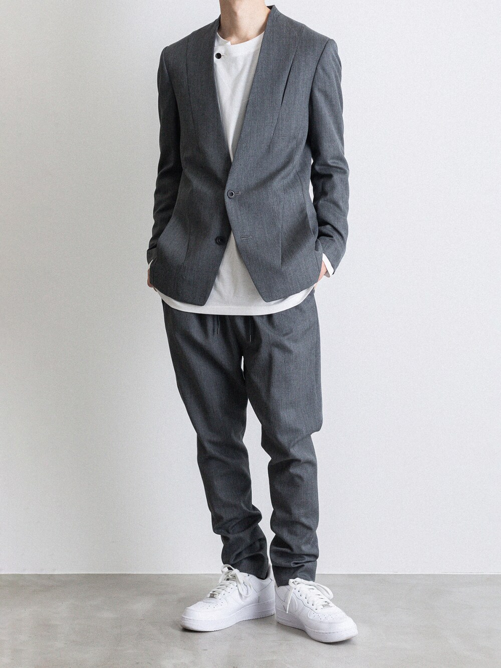 グレー系のその他パンツ、ホワイト系のTシャツ/カットソー、グレー系のノーカラージャケットを着用したメンズの冬コーディネートの2枚目の写真