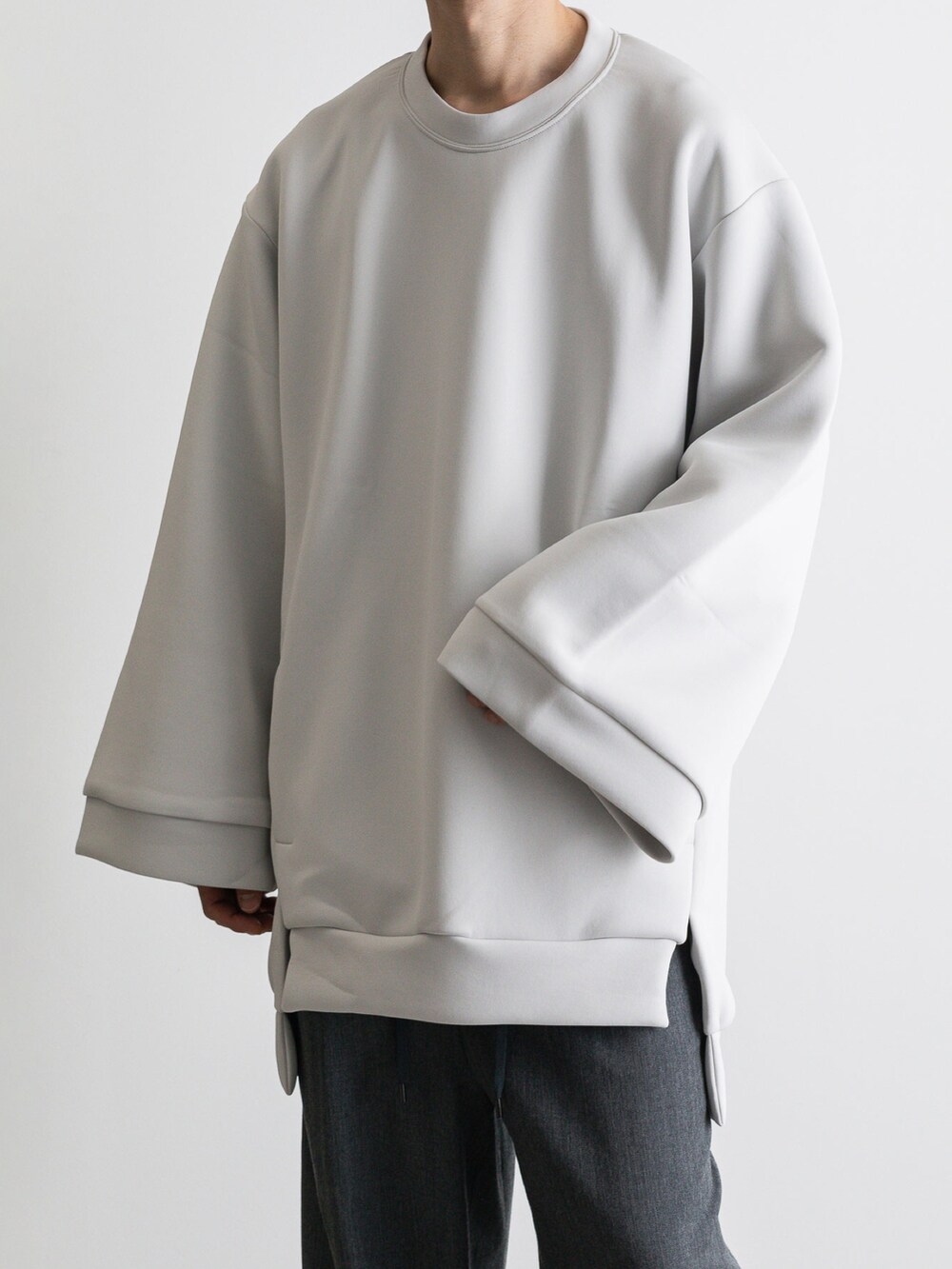 グレー系のその他パンツ、グレー系のTシャツ/カットソー、グリーン系のトレンチコートを着用したメンズの冬コーディネートの5枚目の写真