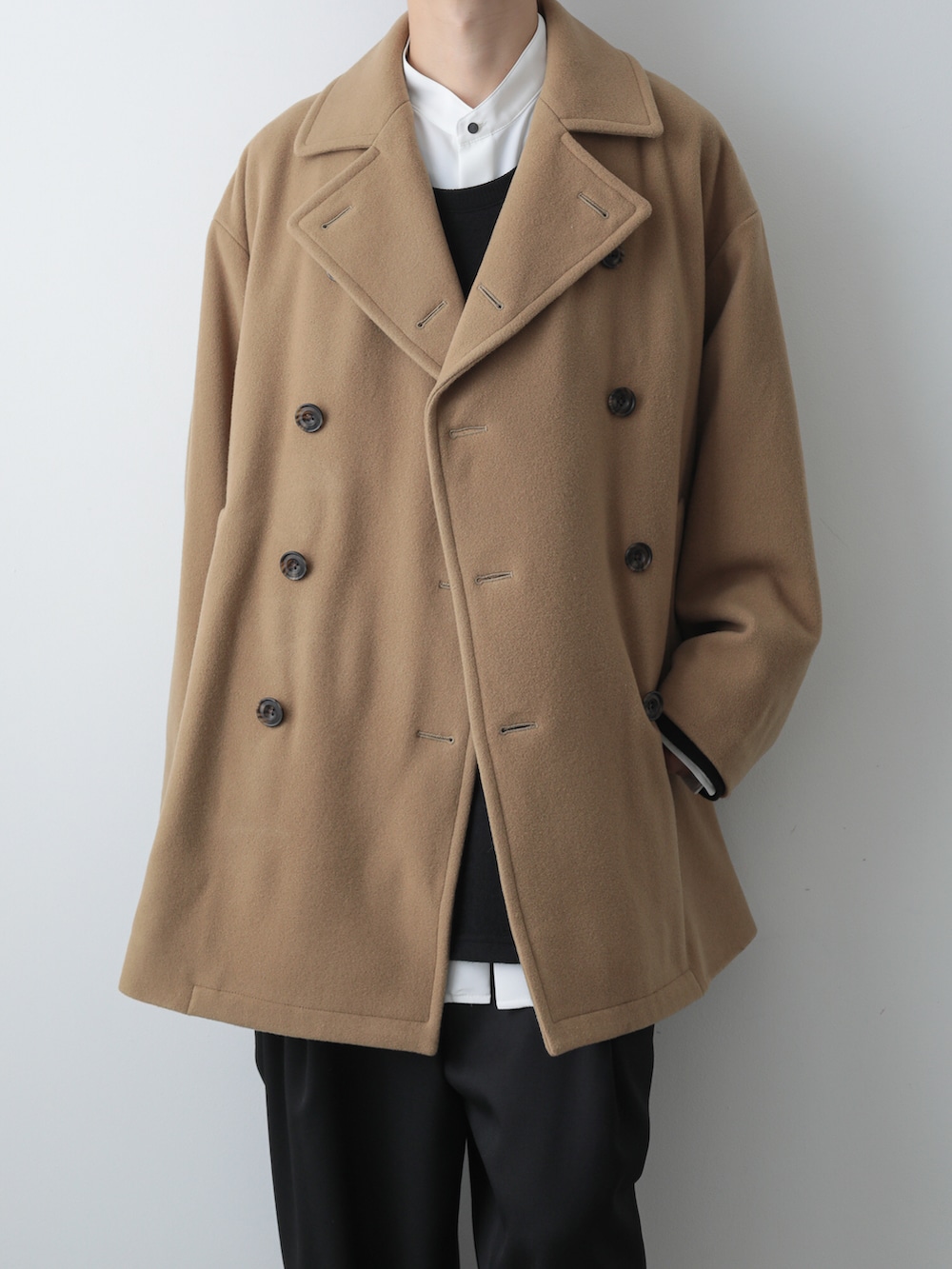 ベージュ系のピーコート、ホワイト系のシャツ/ブラウス、ブラック系のTシャツ/カットソーを着用したメンズの秋コーディネートの3枚目の写真