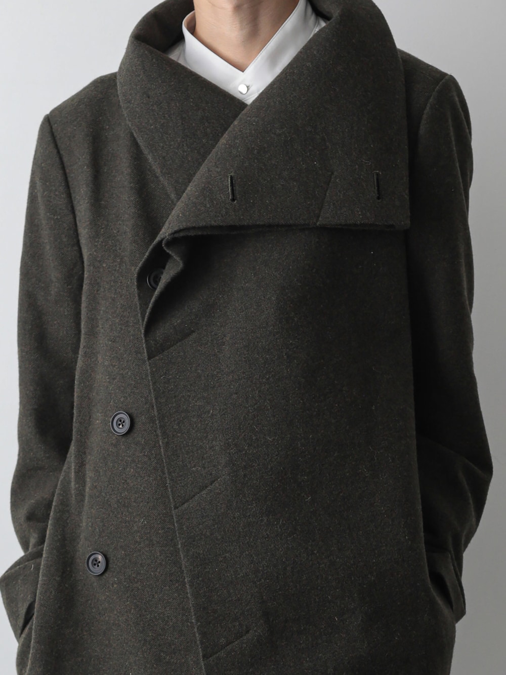 グリーン系のトレンチコート、ホワイト系のシャツ/ブラウス、グリーン系のスウェットパンツを着用したメンズの秋コーディネートの2枚目の写真