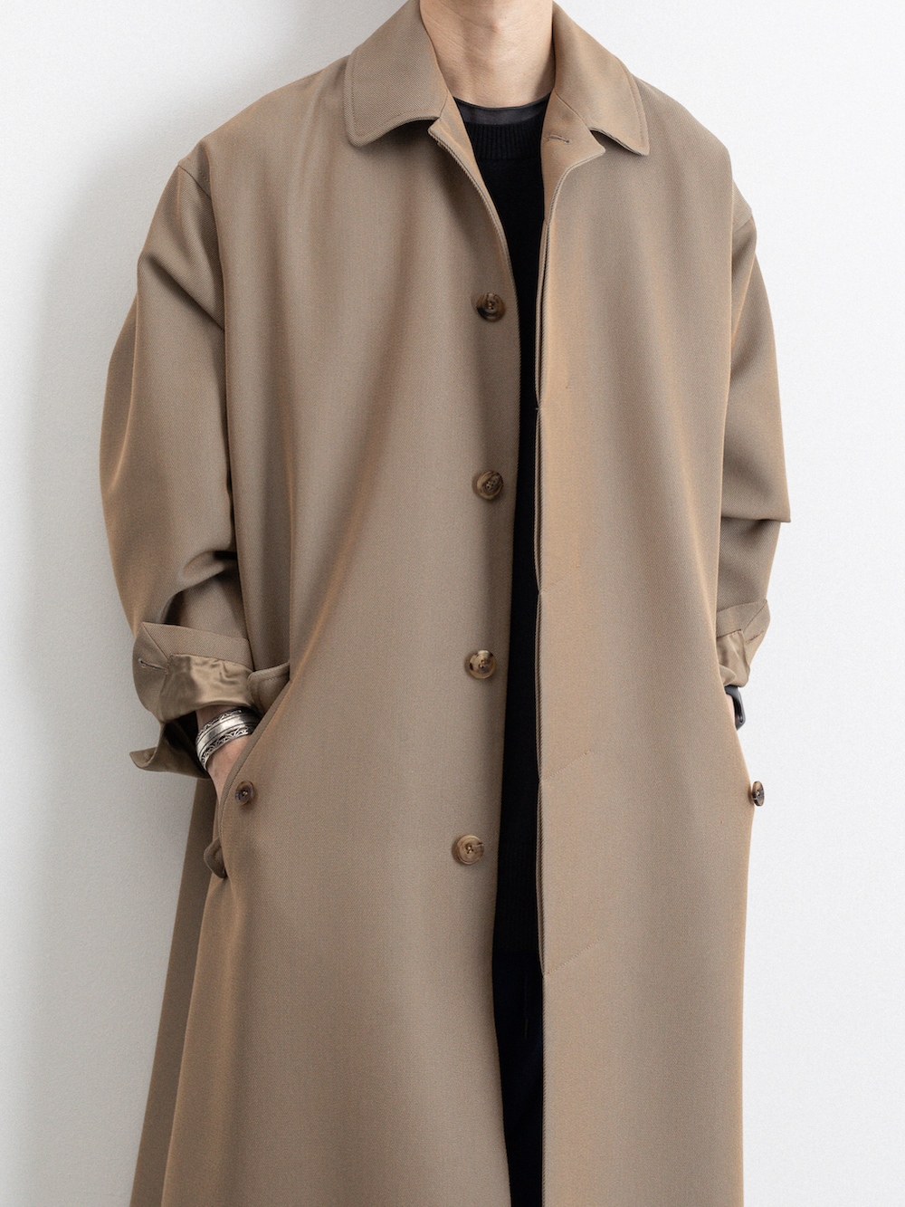 ベージュ系のステンカラーコート、ブルー系のその他パンツを着用したメンズの冬コーディネートの3枚目の写真