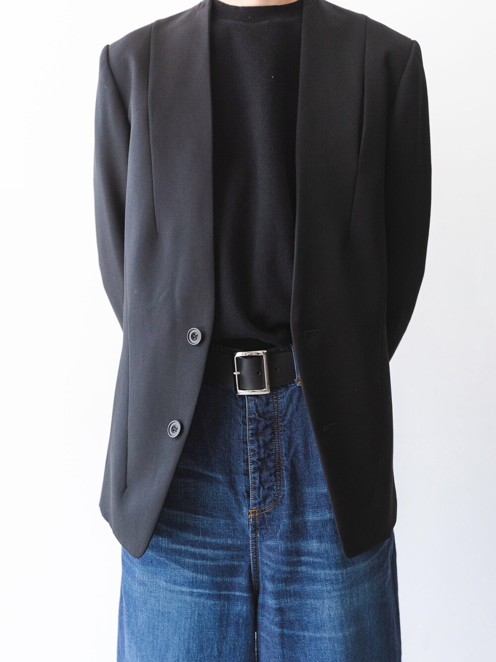 ブルー系のデニムパンツ、ブラック系のノーカラージャケット、ブラック系のベルトを着用したメンズの夏コーディネートの3枚目の写真