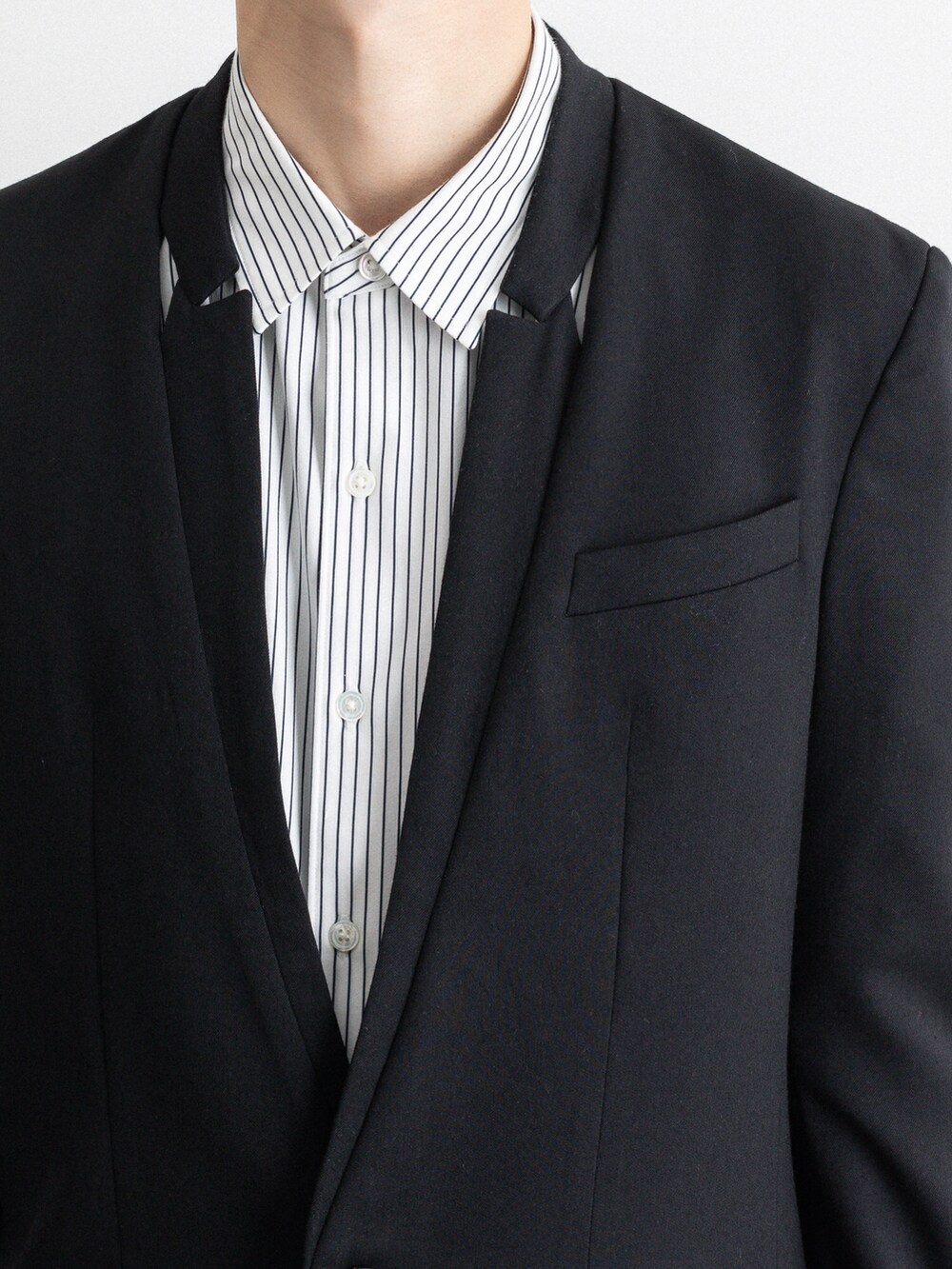 ブラック系のテーラードジャケット、ベージュ系のその他パンツを着用したメンズの冬コーディネートの3枚目の写真