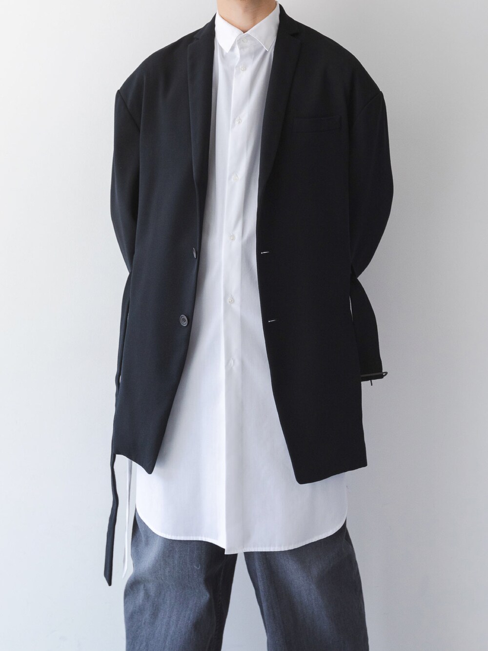 ブラック系のデニムパンツ、ホワイト系のシャツ/ブラウス、ブラック系のテーラードジャケットを着用したメンズの夏コーディネートの3枚目の写真