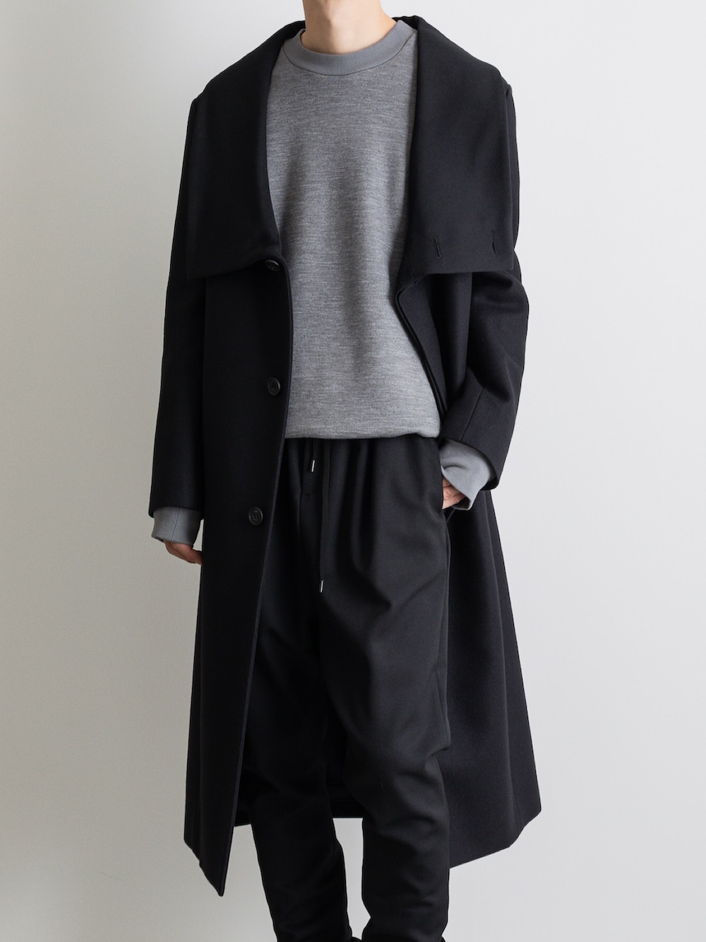 ブラック系のその他パンツ、ブラック系のチェスターコートを着用したメンズの冬コーディネートの3枚目の写真