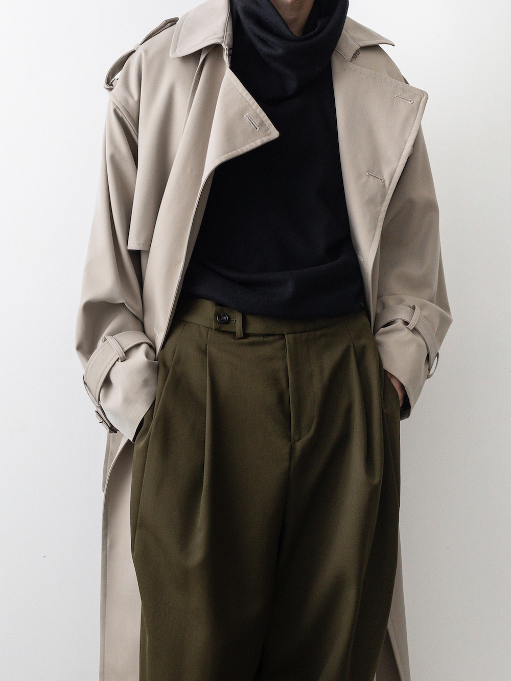 ベージュ系のトレンチコート、グリーン系のその他パンツ、ブラック系のTシャツ/カットソーを着用したメンズの秋コーディネートの3枚目の写真