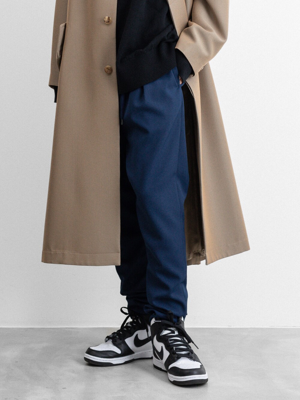 ベージュ系のステンカラーコート、ブルー系のその他パンツを着用したメンズの冬コーディネートの5枚目の写真