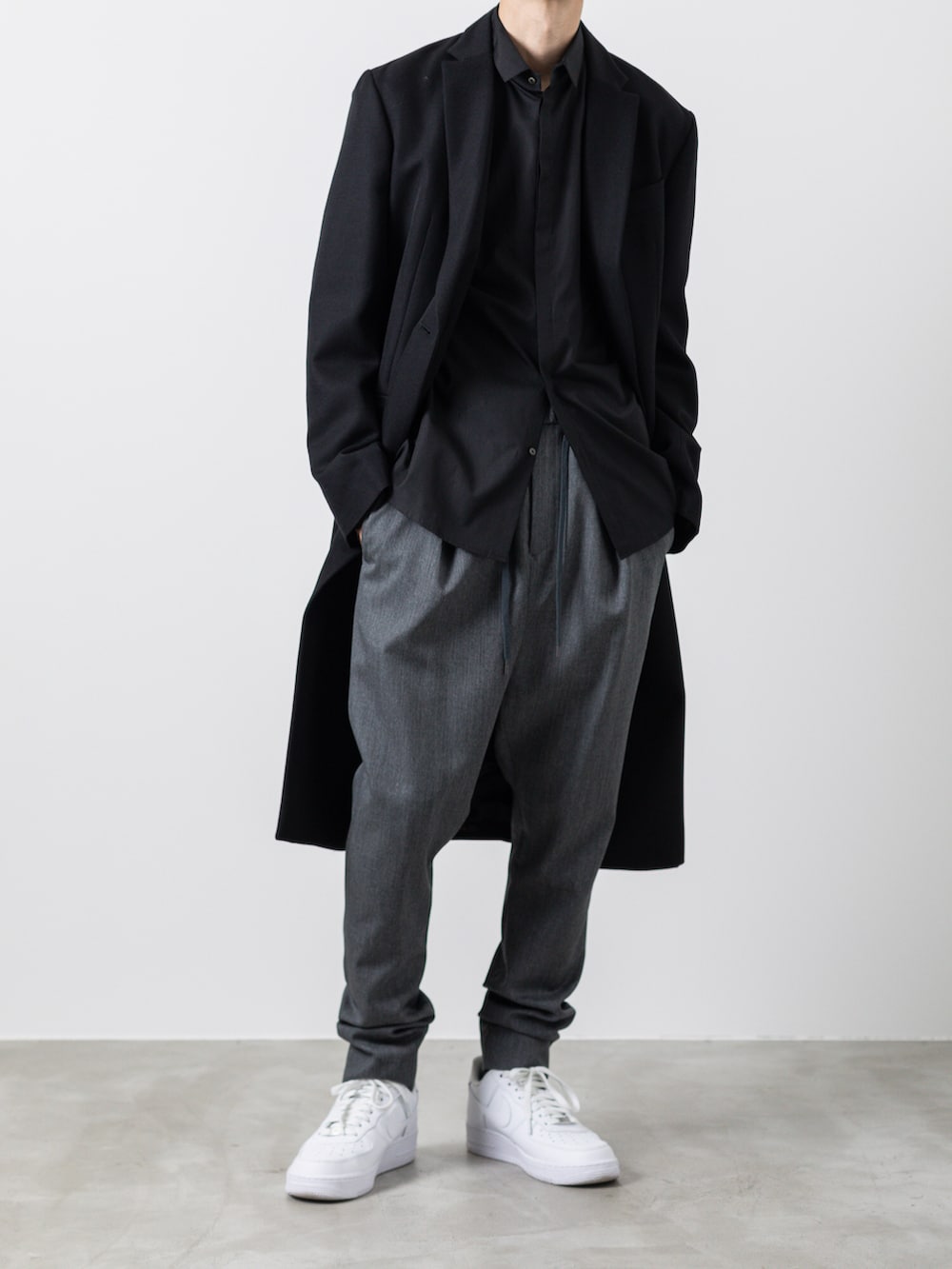 グレー系のその他パンツ、ブラック系のチェスターコート、ブラック系のシャツ/ブラウスを着用したメンズの冬コーディネートの2枚目の写真