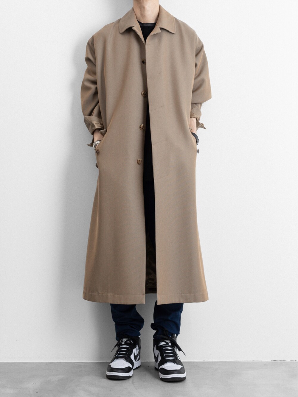 ベージュ系のステンカラーコート、ブルー系のその他パンツを着用したメンズの冬コーディネートの4枚目の写真