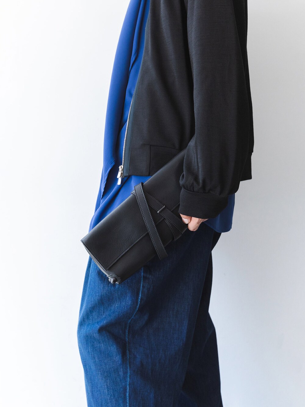 ブルー系のシャツ/ブラウス、ブラック系のニット/セーター、ブルー系のデニムパンツを着用したメンズの秋コーディネートの4枚目の写真