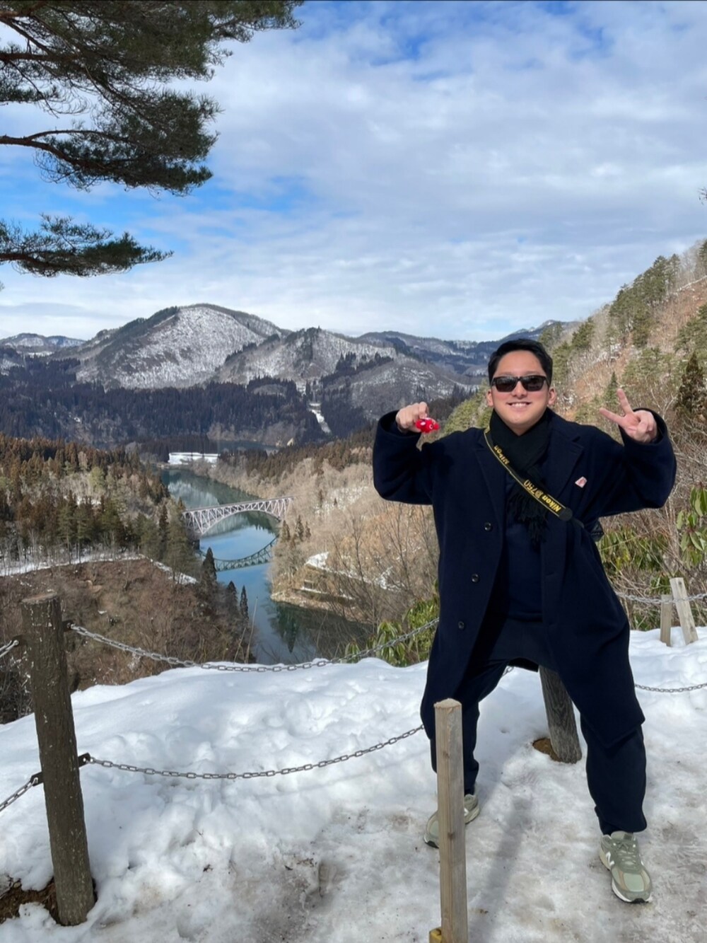 ブルー系のチェスターコート、グリーン系のスニーカー、グレー系のスニーカーを着用したメンズの春コーディネートの2枚目の写真