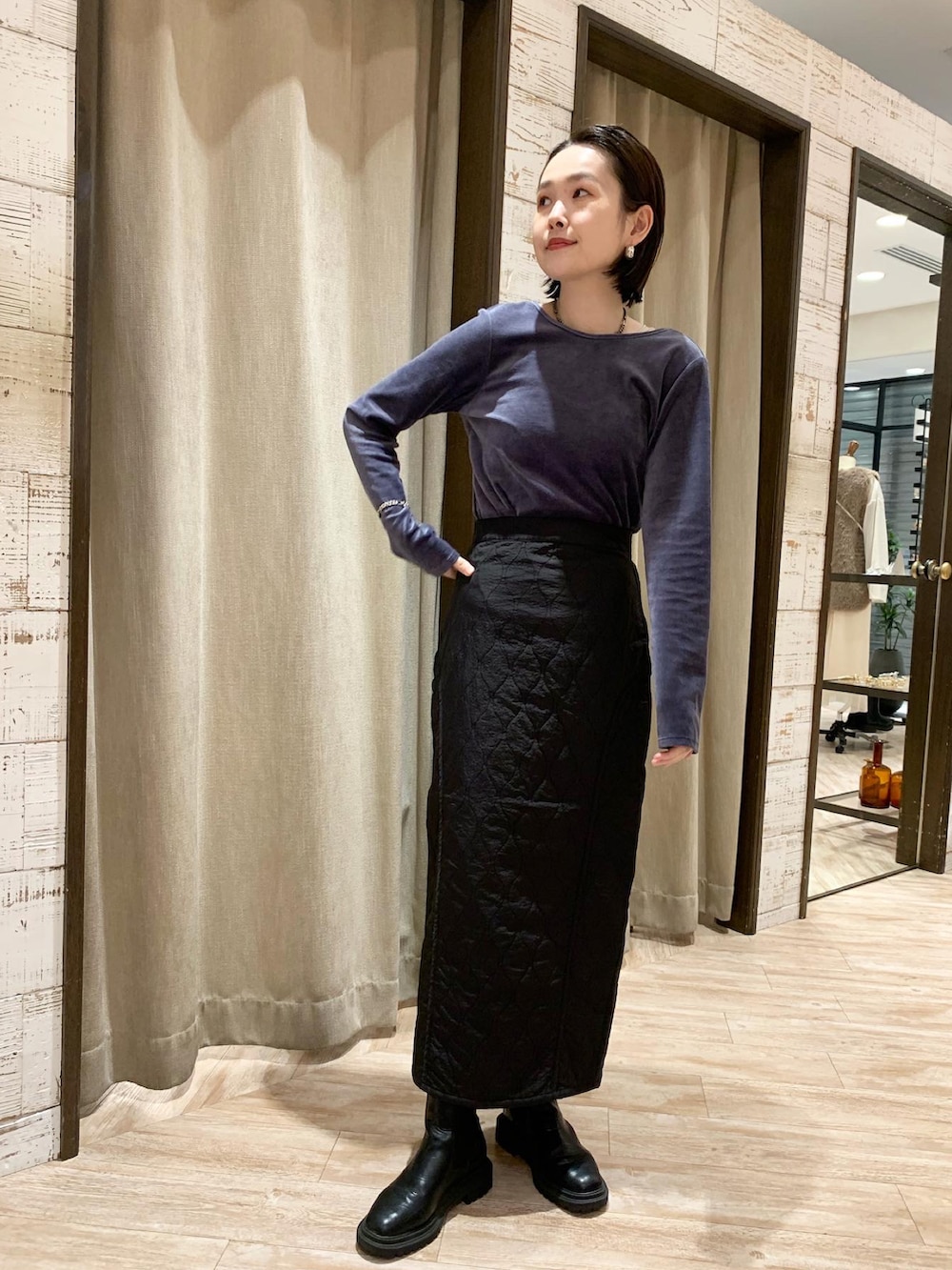 ブルー系のトップス、ブラック系のスカートを着用したレディースの秋コーディネートの2枚目の写真