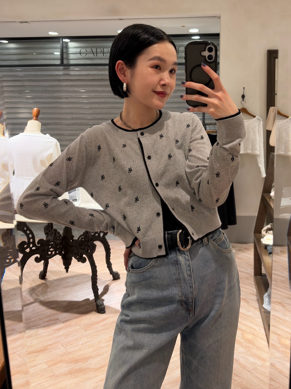 グレー系のカーディガン/ボレロ、ブルー系のデニムパンツ、ブラック系のベルトを着用したレディースの春コーディネートの2枚目の写真