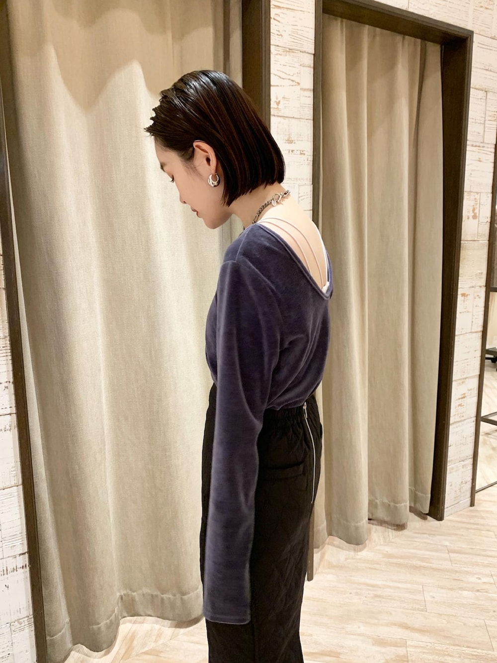 ブルー系のトップス、ブラック系のスカートを着用したレディースの秋コーディネートの3枚目の写真