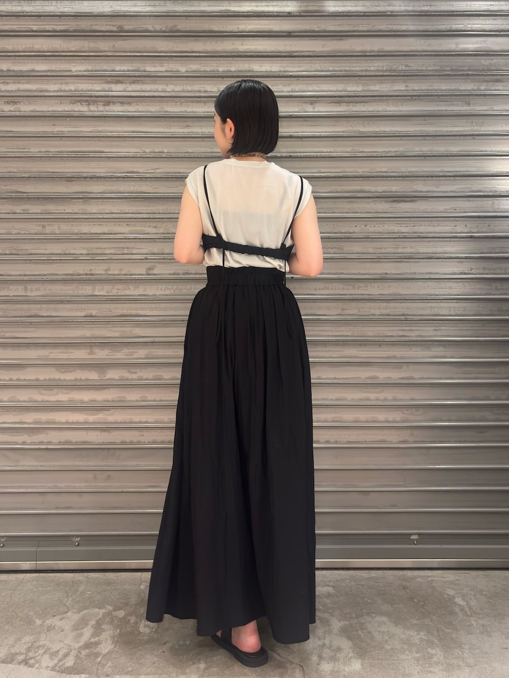 シルバー系のTシャツ/カットソー、ブラック系のワンピース、ブラック系のサンダルを着用したレディースの春コーディネートの2枚目の写真