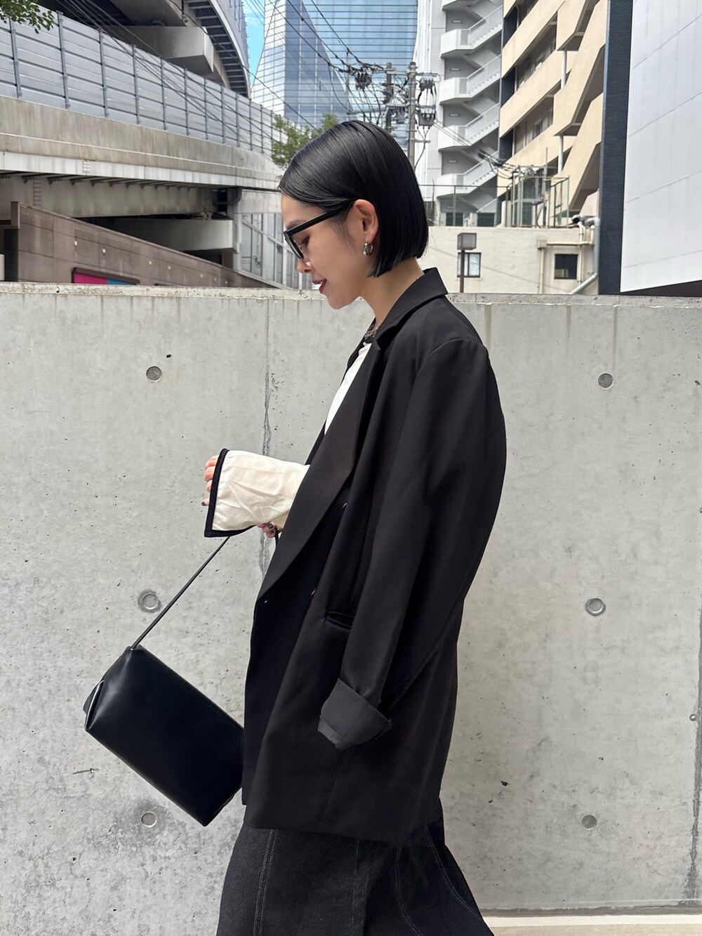 ブラック系のスカート、ホワイト系のTシャツ/カットソーを着用したレディースの秋コーディネートの2枚目の写真