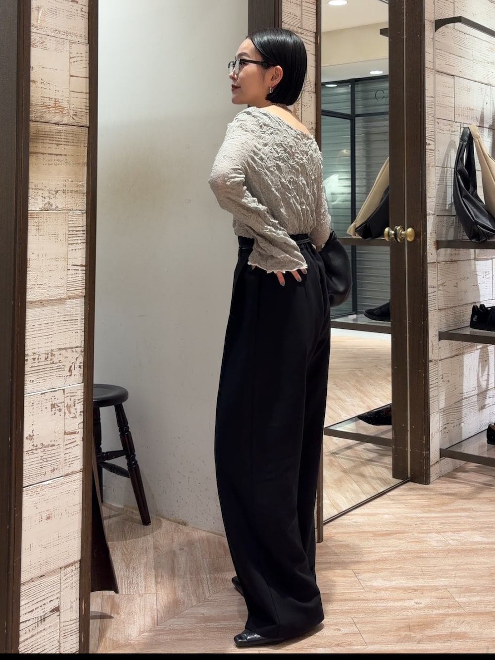 グレー系のニット/セーター、ブラック系のその他パンツ、ブラック系のショルダーバッグを着用したレディースの春コーディネートの2枚目の写真