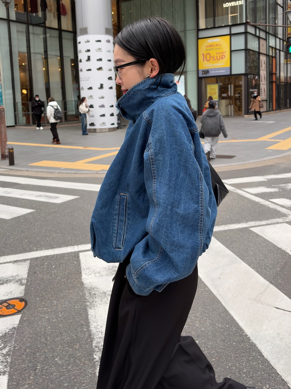 ブルー系のブルゾン、ブラック系のニット/セーター、ブラック系のショルダーバッグを着用したレディースの冬コーディネートの2枚目の写真