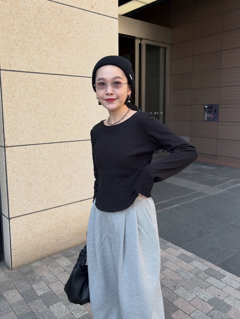 ブラック系のTシャツ/カットソー、グレー系のその他パンツ、ブラック系のショルダーバッグを着用したレディースの春コーディネートの2枚目の写真