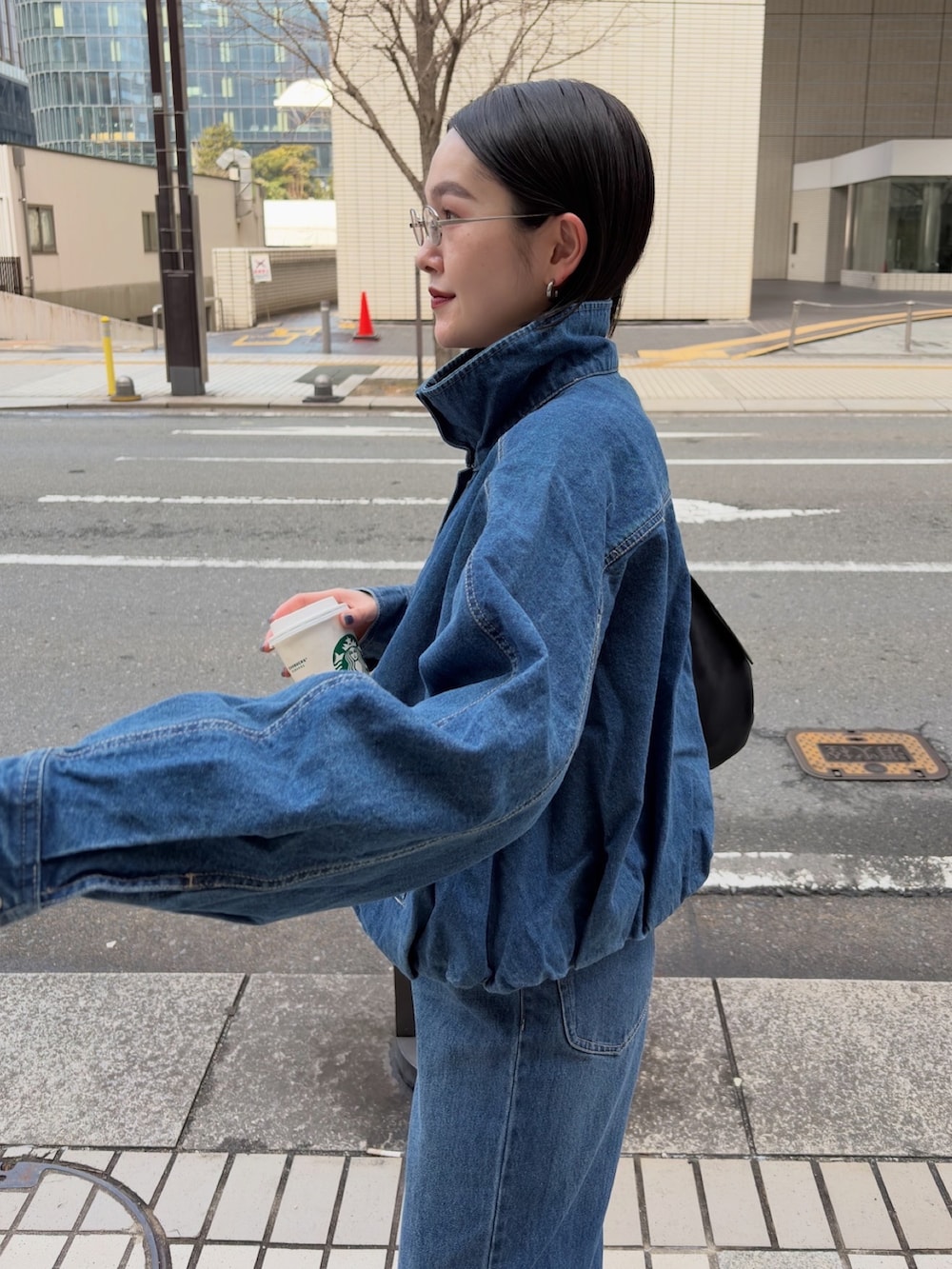 ブルー系のブルゾン、ブルー系のデニムパンツ、ブラック系のショルダーバッグを着用したレディースの冬コーディネートの3枚目の写真