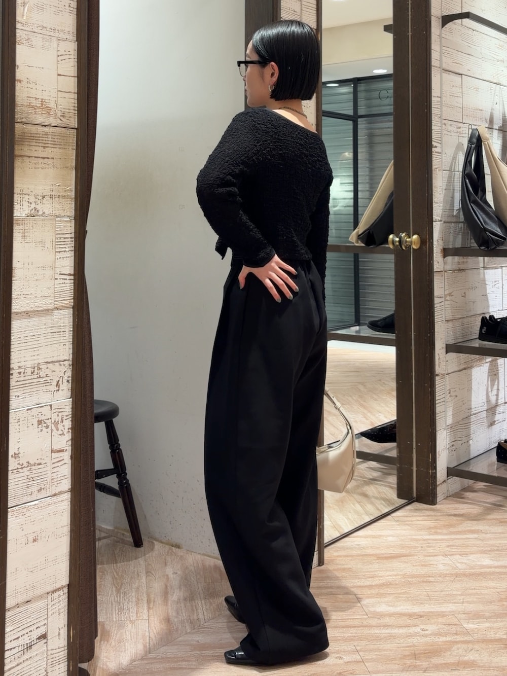 ブラック系のシャツ/ブラウス、ブラック系のその他パンツ、ホワイト系のショルダーバッグを着用したレディースの春コーディネートの2枚目の写真