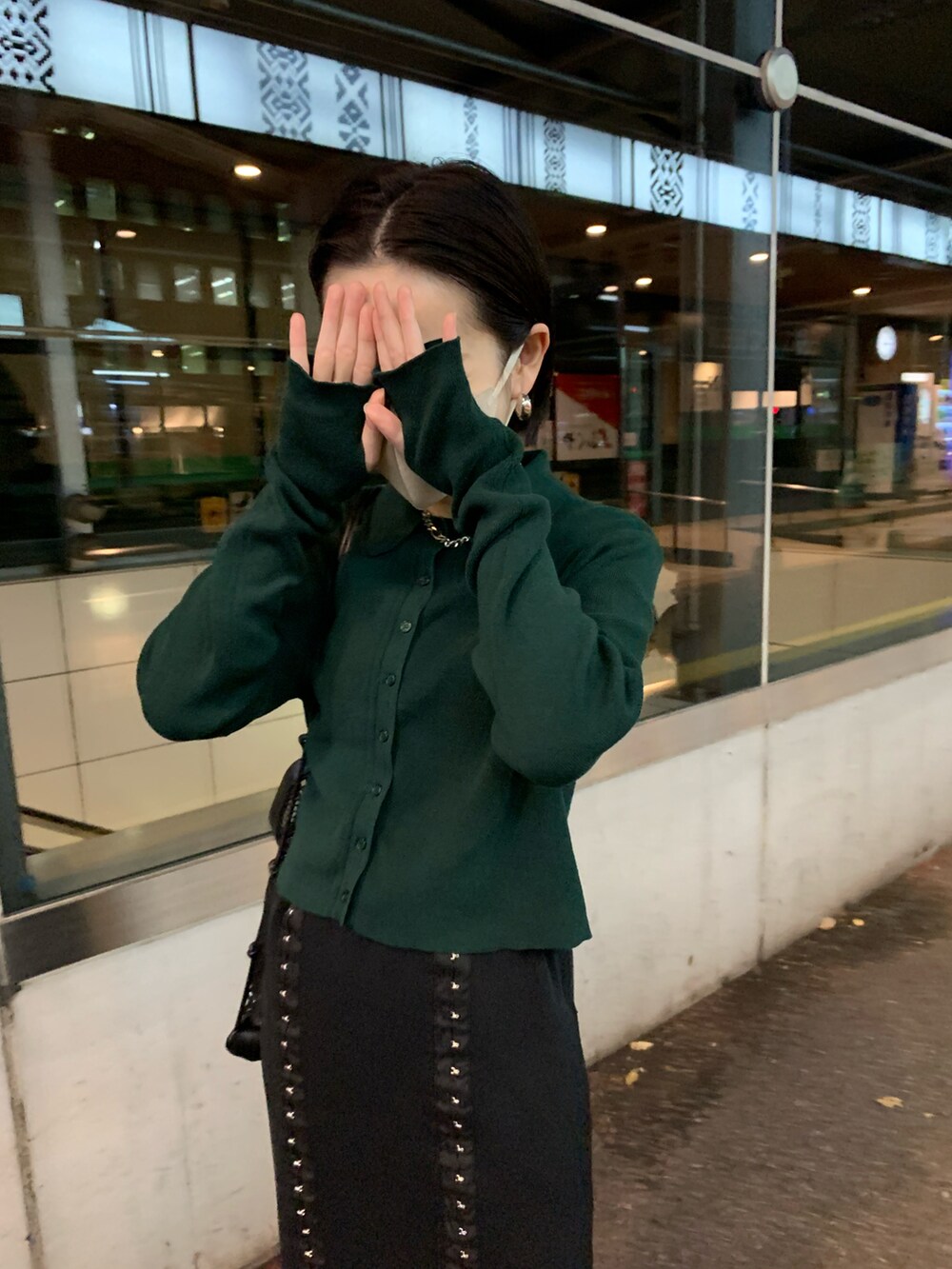 グリーン系のカーディガン/ボレロ、ブラック系のスカートを着用したレディースの秋コーディネートの2枚目の写真