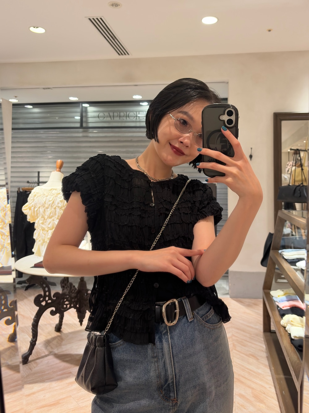 ブラック系のシャツ/ブラウス、ブルー系のデニムパンツ、ブラック系のショルダーバッグを着用したレディースの夏コーディネートの2枚目の写真