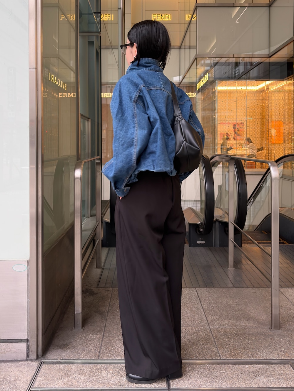 ブルー系のブルゾン、ブラック系のニット/セーター、ブラック系のショルダーバッグを着用したレディースの冬コーディネートの3枚目の写真