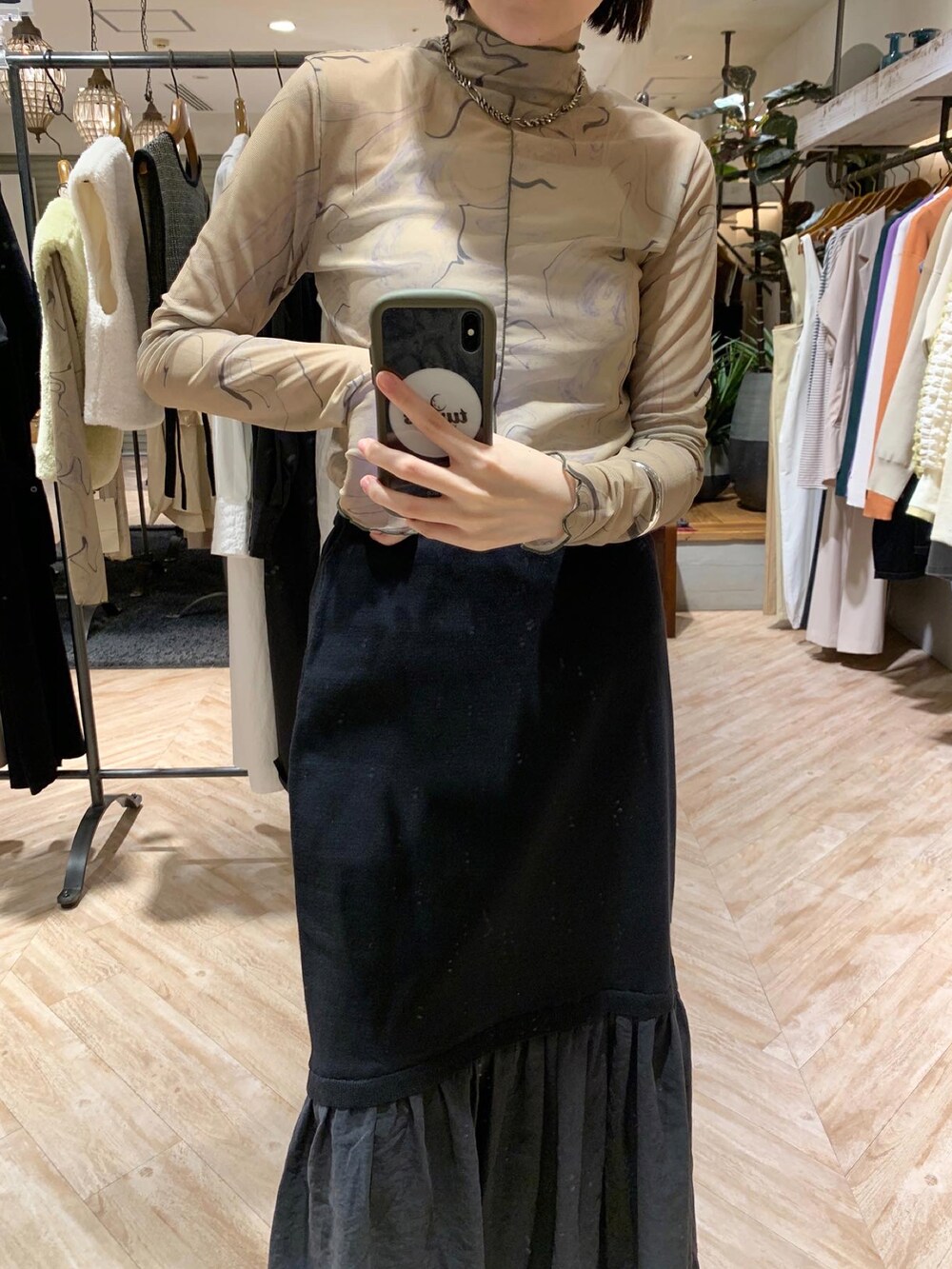 グリーン系のTシャツ/カットソー、ブラック系のスカートを着用したレディースの秋コーディネートの2枚目の写真