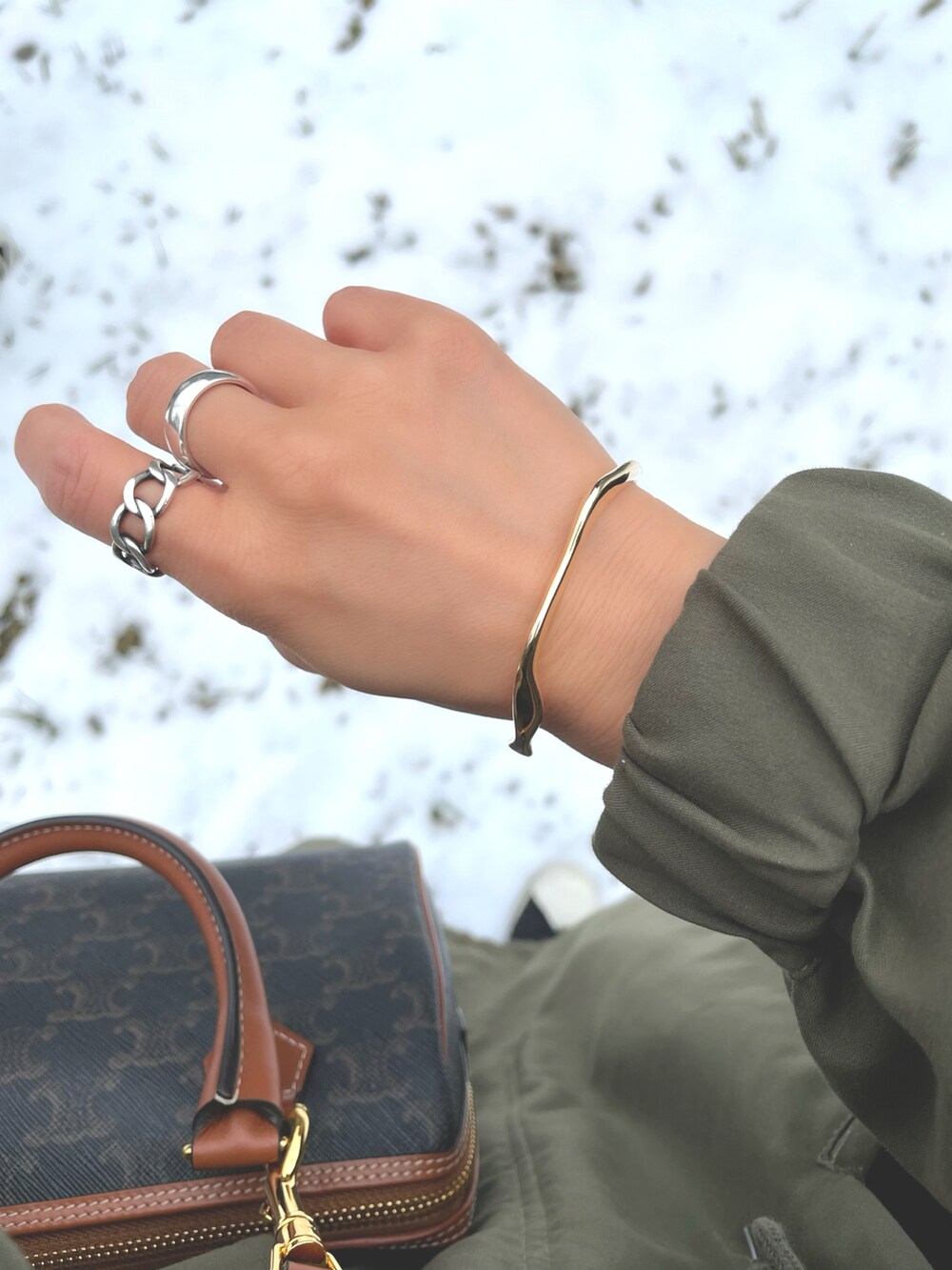 ブラック系のスニーカー、グリーン系のモッズコート、ホワイト系のスウェットパンツを着用したレディースの春コーディネートの2枚目の写真