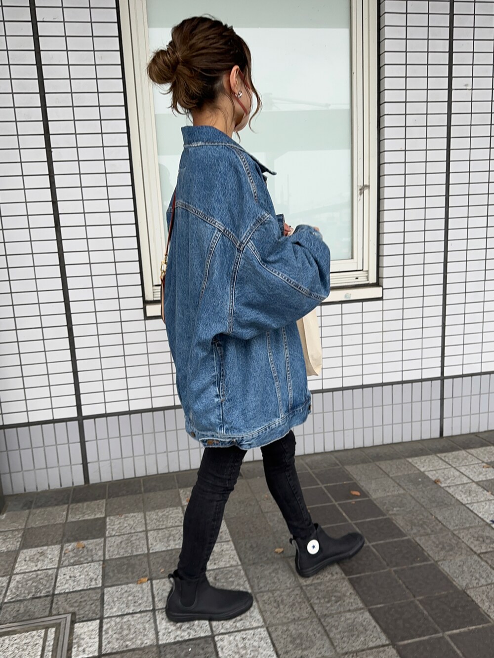 ブルー系のデニムジャケット、ブルー系のTシャツ/カットソー、ブラック系のデニムパンツを着用したレディースの春コーディネートの4枚目の写真