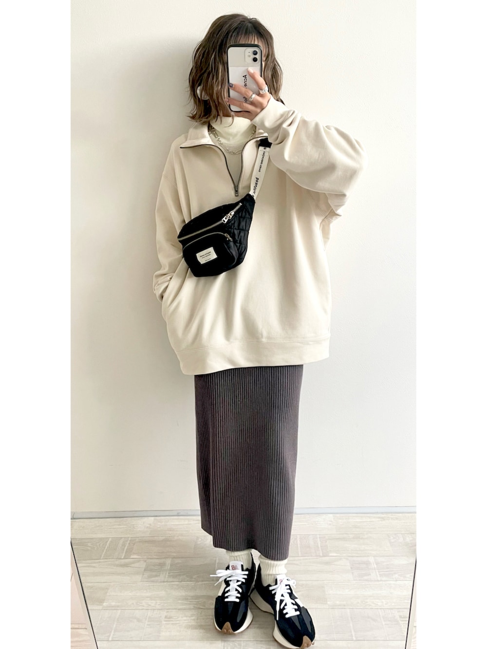 ホワイト系のスウェット、グレー系のスカート、ブラック系のボディバッグ/ウエストポーチを着用したレディースの冬コーディネートの2枚目の写真