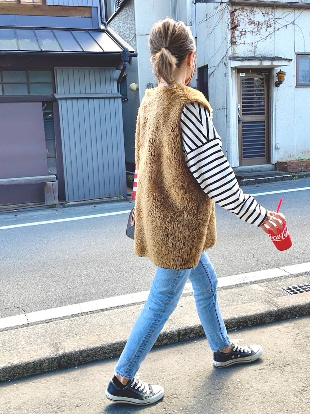ホワイト系のTシャツ/カットソー、ブルー系のデニムパンツ、ブラウン系のベストを着用したレディースの春コーディネートの2枚目の写真