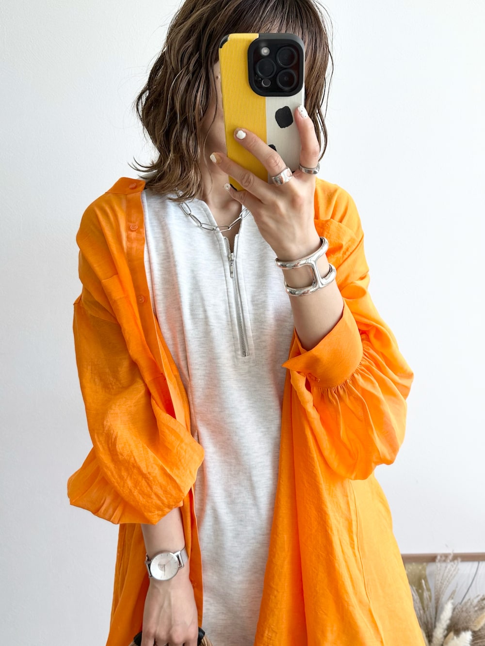 ベージュ系のワンピース、オレンジ系のシャツ/ブラウス、ホワイト系のサンダルを着用したレディースの春コーディネートの4枚目の写真