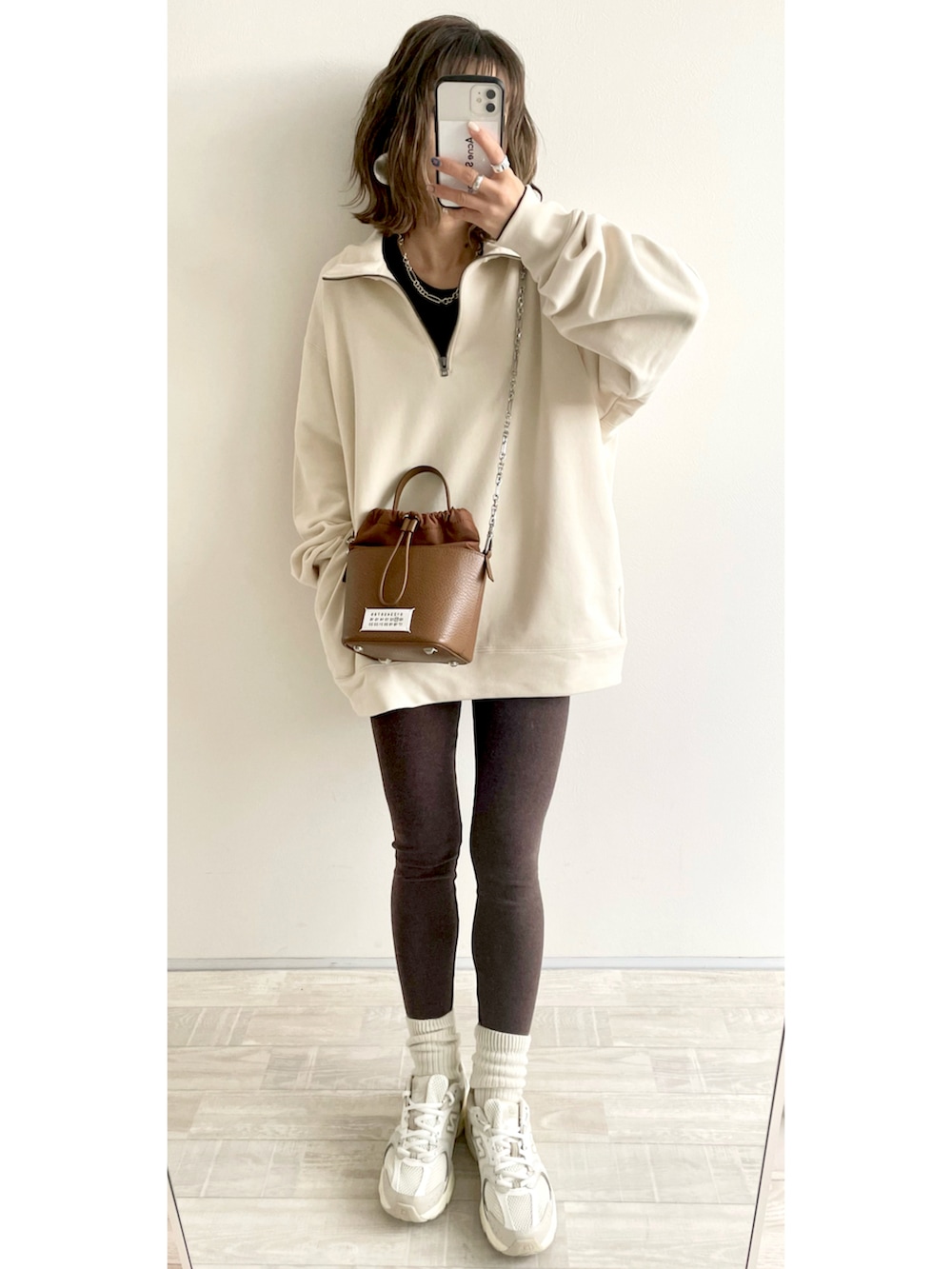 ホワイト系のスウェット、グレー系のスカート、ブラック系のボディバッグ/ウエストポーチを着用したレディースの冬コーディネートの3枚目の写真