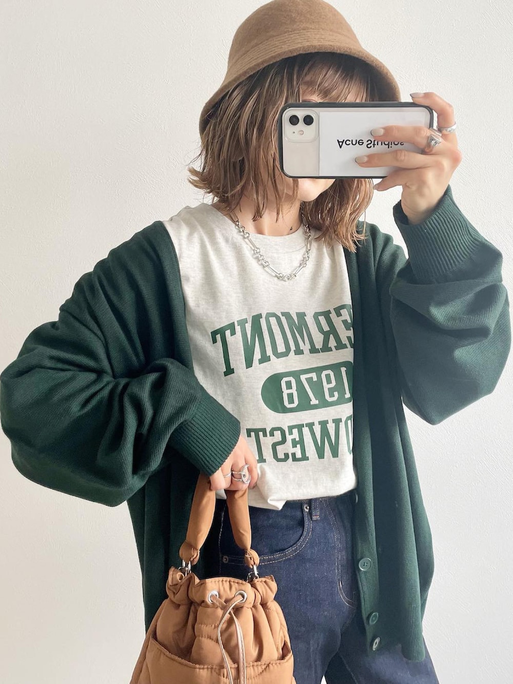 グリーン系のカーディガン/ボレロ、ホワイト系のTシャツ/カットソー、ブルー系のデニムパンツを着用したレディースの秋コーディネートの2枚目の写真