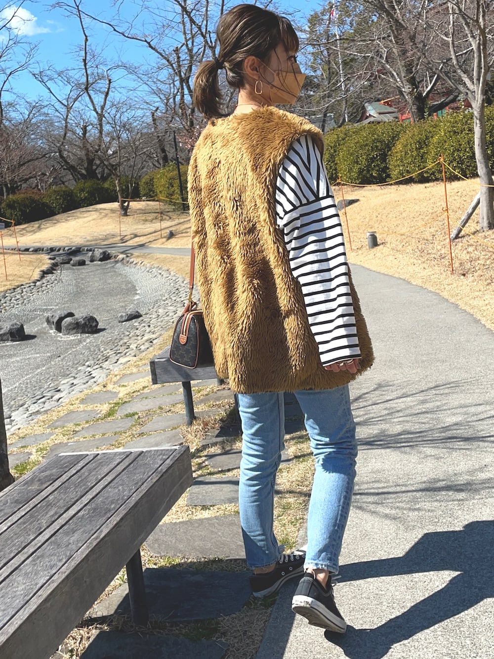 ホワイト系のTシャツ/カットソー、ブルー系のデニムパンツ、ブラウン系のベストを着用したレディースの春コーディネートの3枚目の写真