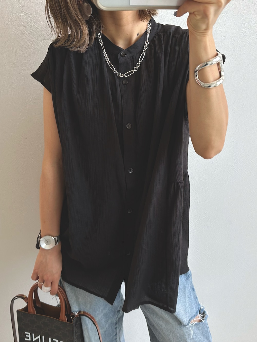 ブラック系のシャツ/ブラウス、ブルー系のデニムパンツ、ベージュ系のショルダーバッグを着用したレディースの夏コーディネートの2枚目の写真