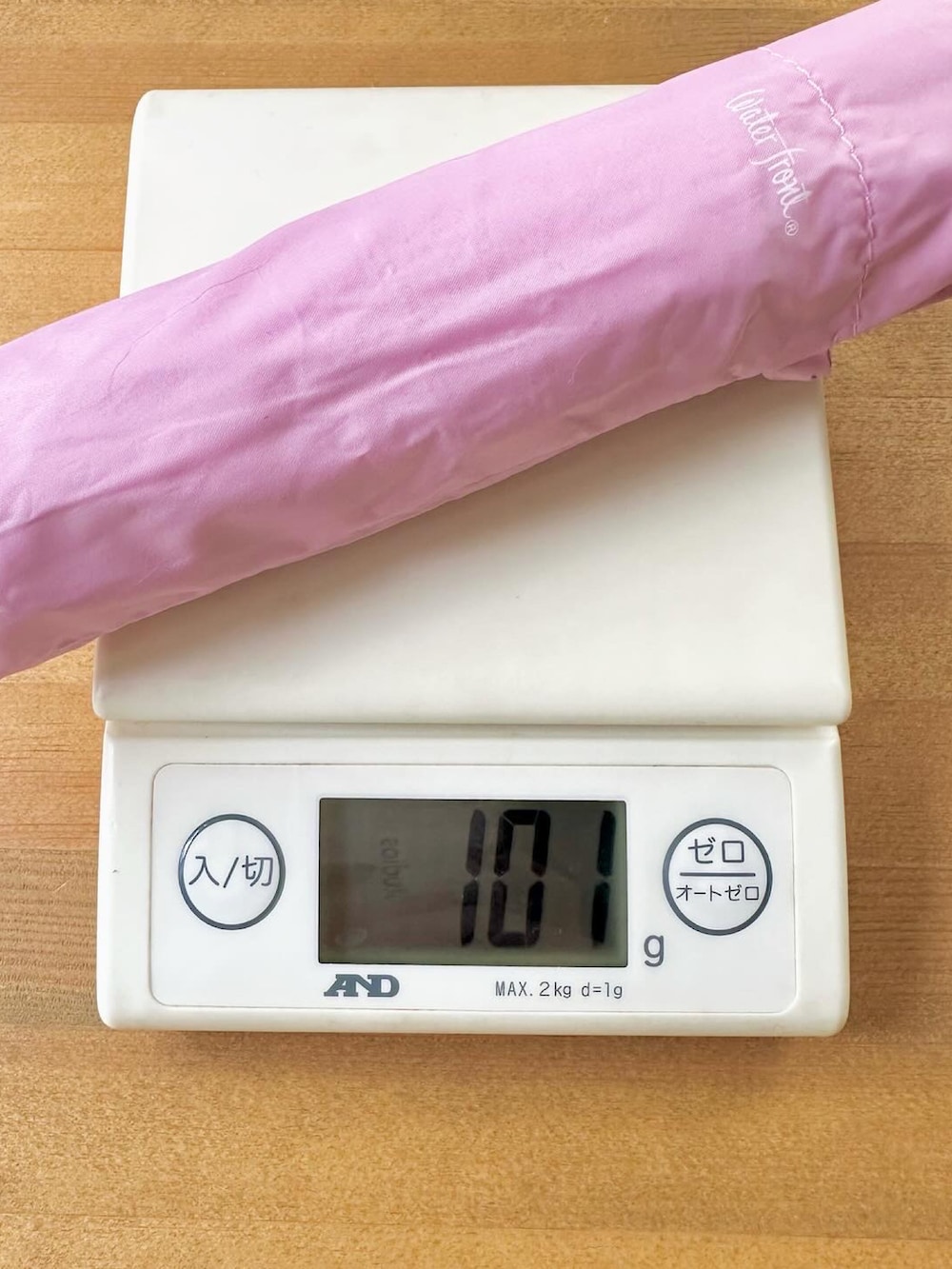 ピンク系の折りたたみ傘を着用したレディースの冬コーディネートの3枚目の写真