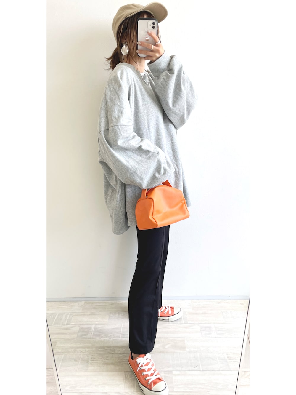 グレー系のスウェット、ブラック系のパンツ、オレンジ系のスニーカーを着用したレディースの春コーディネートの2枚目の写真
